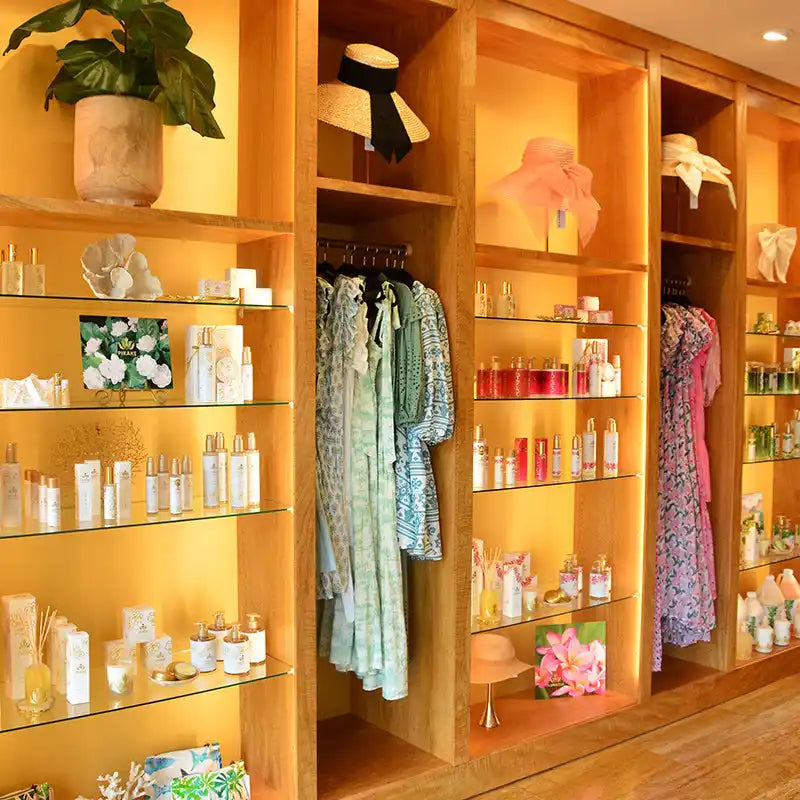 Built-in wooden shelving unit displaying beauty products, clothing, and decorative items.